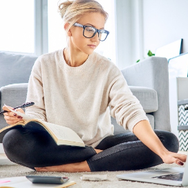 girl with reading glasses viewing her laptop