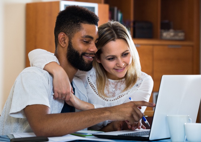 A couple looking at their laptop.