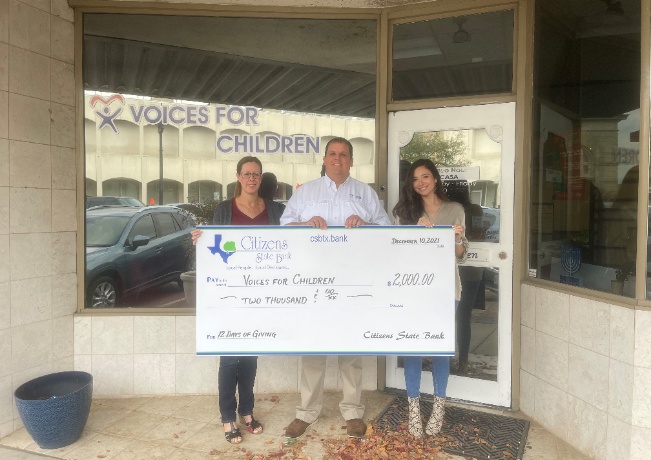 three people holding a big check