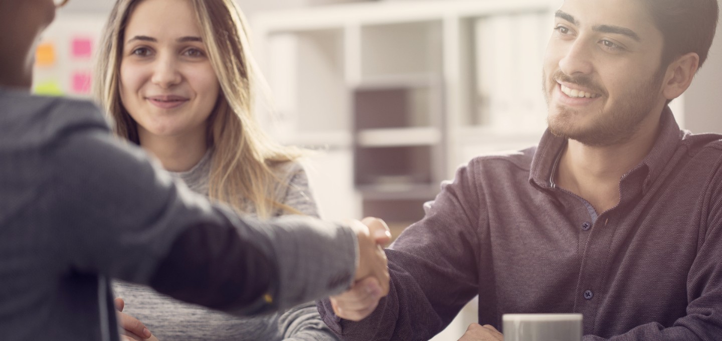 a couple shaking hands with their  bank representative