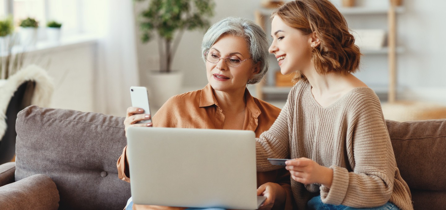 mother and daughter using a mobile and desktop to make an online purchase