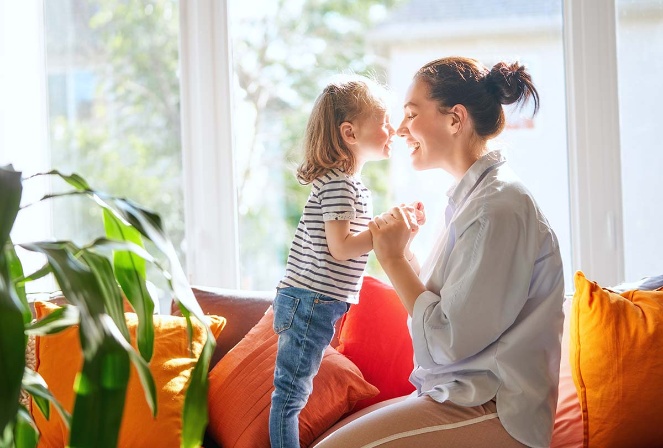 mother and daughter playing on a couch