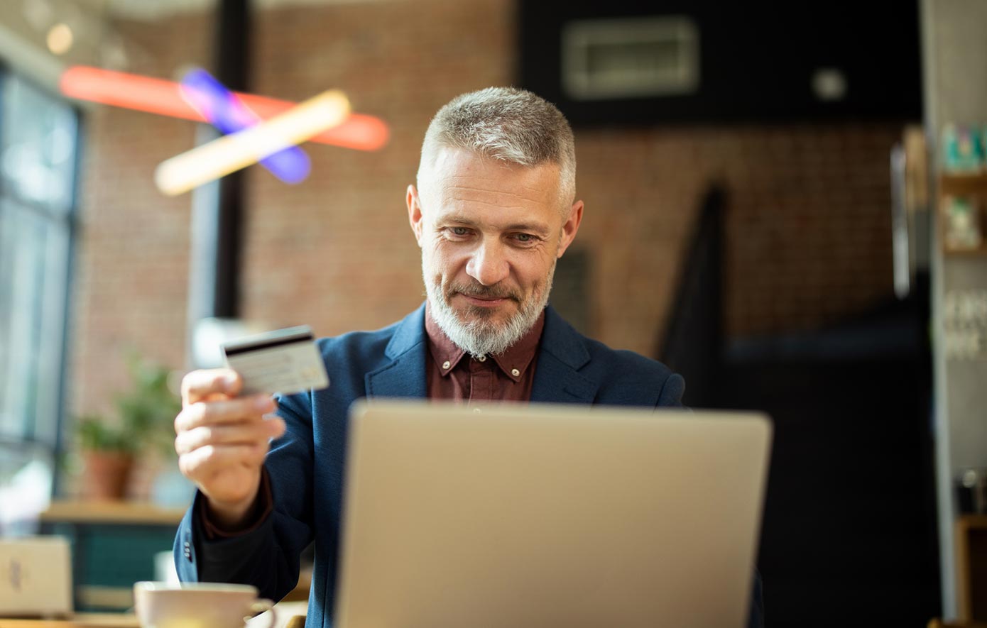 Business man using a business credit card on a laptop computer in his office