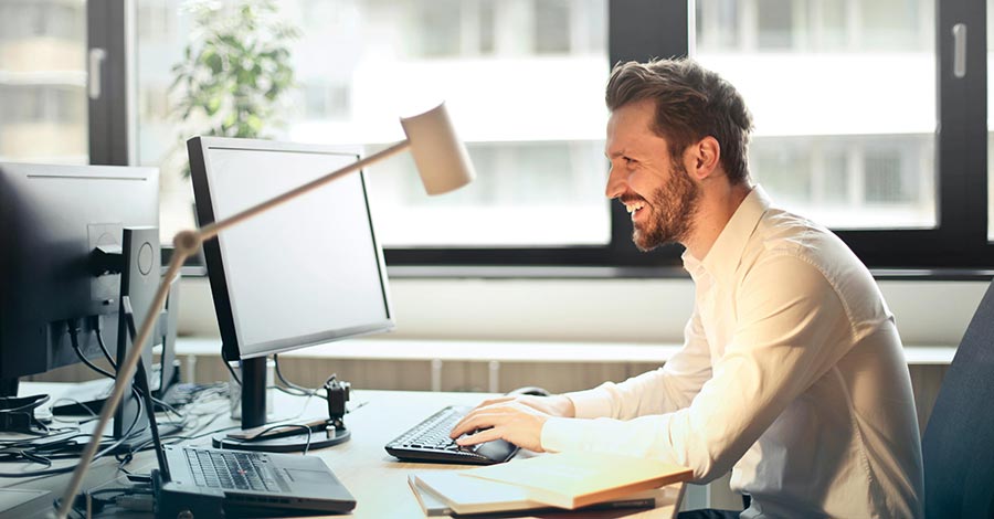 A man in his office using a desktop computer