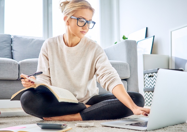 woman with glasses working on her laptop