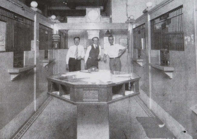 three men standing in a bank