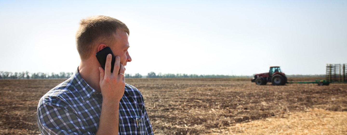 a farmer on his mobile device in the field