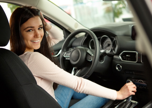 a young lady sitting in her new car